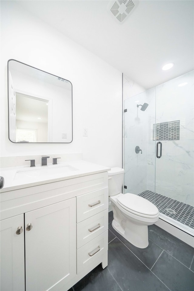 bathroom with walk in shower, vanity, toilet, and tile patterned floors