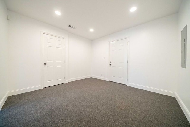 spare room featuring dark carpet and electric panel