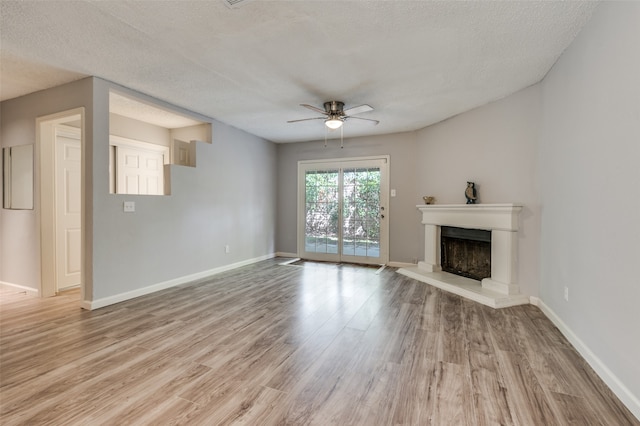 unfurnished living room with ceiling fan, a textured ceiling, and light hardwood / wood-style flooring