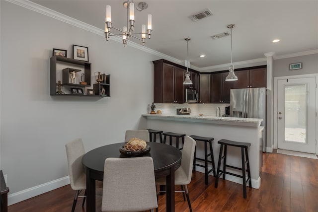 dining area with dark hardwood / wood-style floors, ornamental molding, and an inviting chandelier