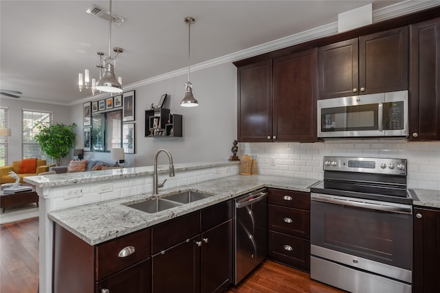 kitchen featuring dark hardwood / wood-style flooring, kitchen peninsula, sink, and appliances with stainless steel finishes