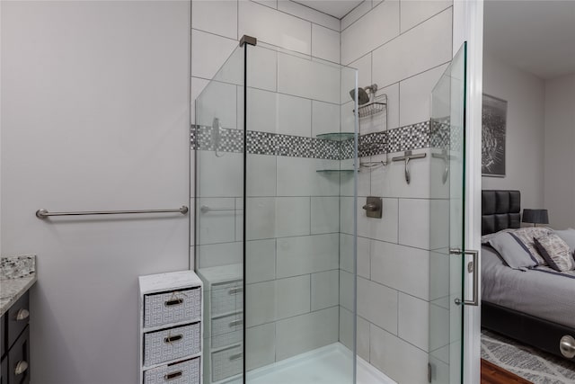 bathroom with a tile shower and vanity