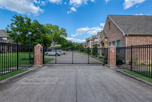 view of gate with a lawn