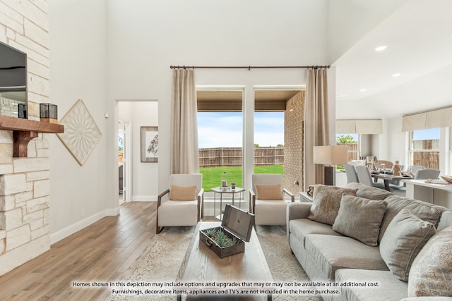 living room featuring light hardwood / wood-style flooring and a towering ceiling