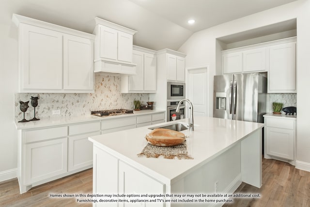 kitchen with white cabinets, sink, a center island with sink, light hardwood / wood-style flooring, and stainless steel appliances