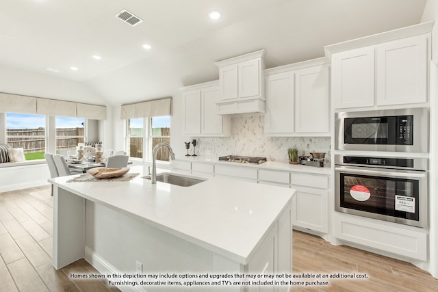 kitchen featuring white cabinets, sink, stainless steel appliances, and a wealth of natural light