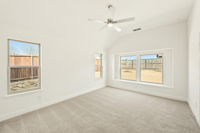 carpeted spare room with vaulted ceiling, plenty of natural light, visible vents, and baseboards