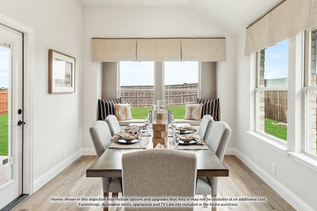 dining room featuring lofted ceiling and light hardwood / wood-style floors