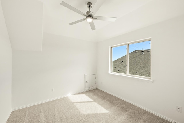 carpeted spare room featuring ceiling fan and baseboards