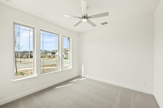 unfurnished room featuring carpet, visible vents, ceiling fan, and baseboards