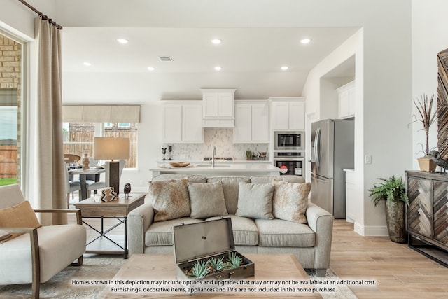 living room featuring light wood-type flooring and sink