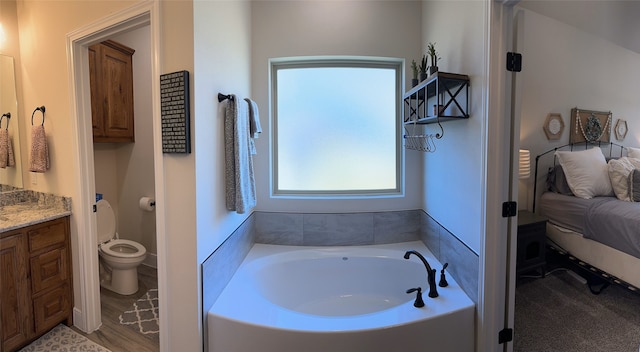 bathroom with vanity, a bathtub, and toilet