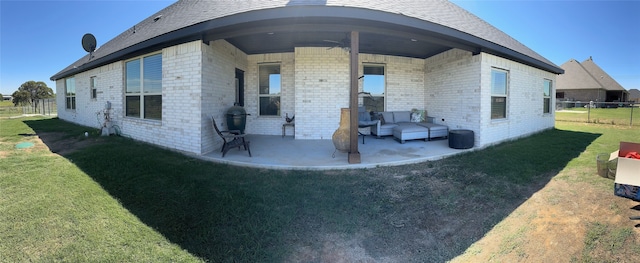 rear view of property with ceiling fan, a yard, and a patio