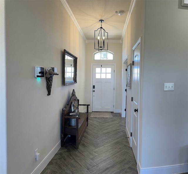 doorway featuring dark parquet flooring, an inviting chandelier, and crown molding