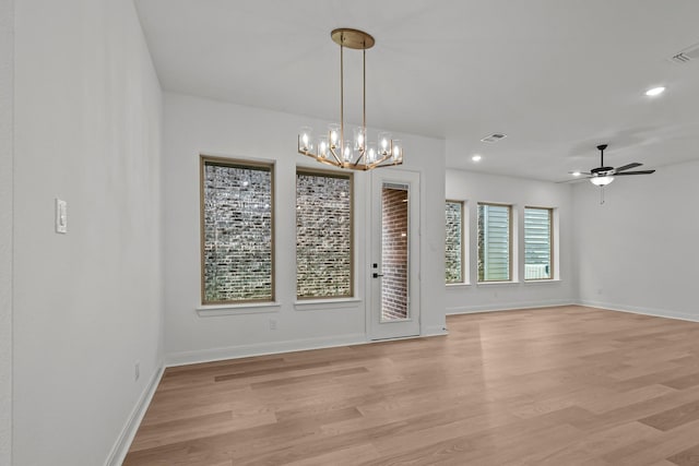 unfurnished room with ceiling fan with notable chandelier and light wood-type flooring