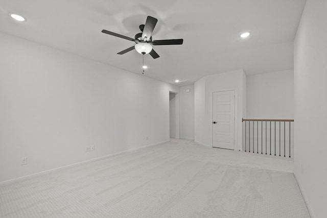 spare room featuring light colored carpet and ceiling fan