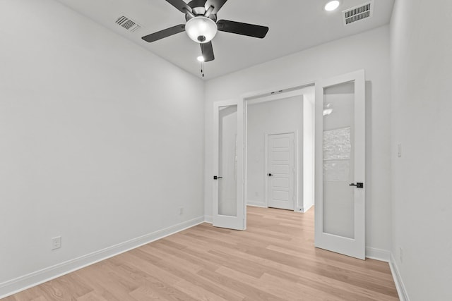 unfurnished bedroom featuring ceiling fan, light wood-type flooring, and french doors