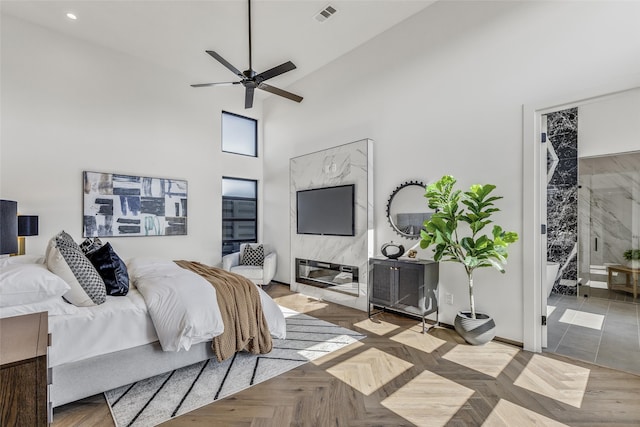 bedroom with ceiling fan, a high ceiling, and light parquet floors