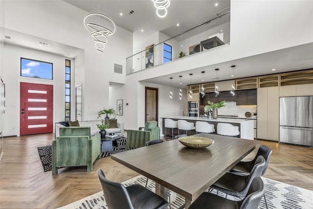 dining room with light parquet flooring and a high ceiling