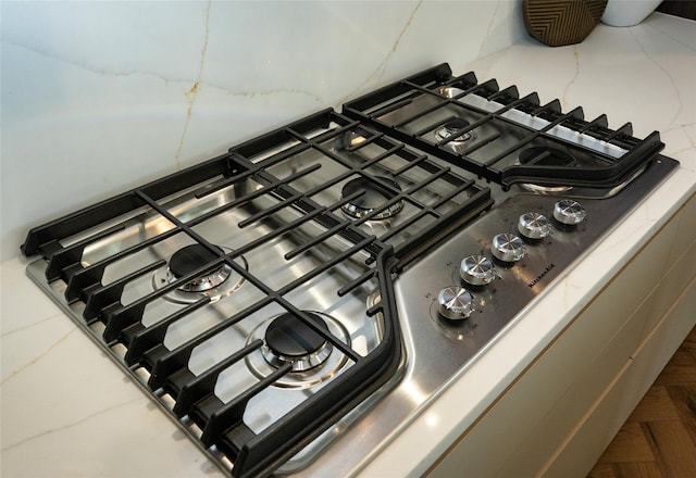 interior details with parquet flooring and stainless steel gas stovetop