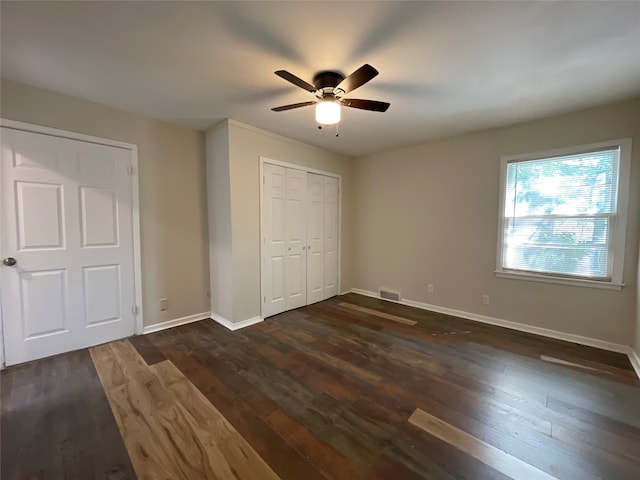 unfurnished bedroom featuring ceiling fan and dark hardwood / wood-style flooring