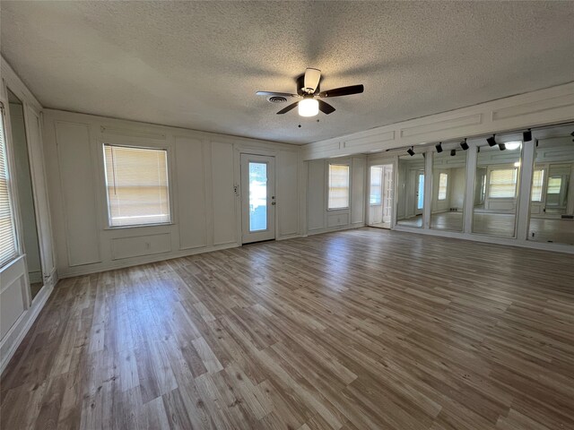 unfurnished room with ceiling fan, a textured ceiling, and light hardwood / wood-style floors