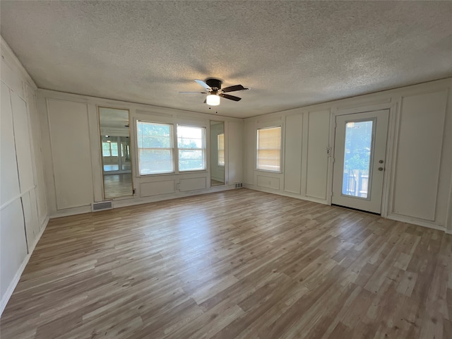 interior space featuring light wood-type flooring, a textured ceiling, and ceiling fan