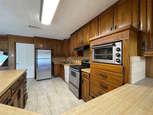 kitchen with a textured ceiling, stainless steel fridge, black electric range, and white dishwasher