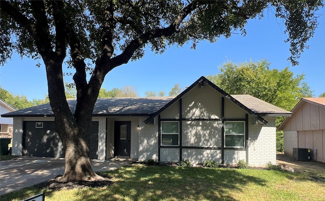 view of front of home with central AC and a front lawn