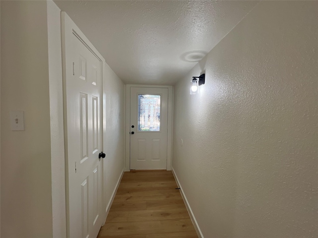 entryway with a textured ceiling and light wood-type flooring