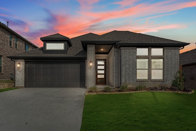 prairie-style house featuring a yard and a garage