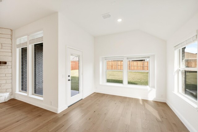 unfurnished room featuring light hardwood / wood-style floors and vaulted ceiling