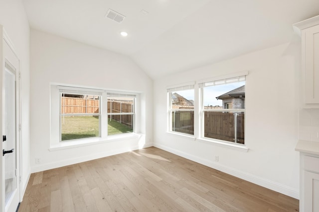 interior space featuring light hardwood / wood-style floors and vaulted ceiling