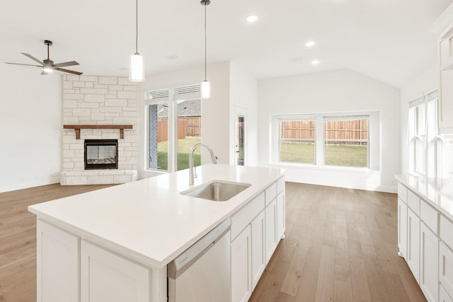 kitchen featuring white dishwasher, plenty of natural light, a center island with sink, and sink