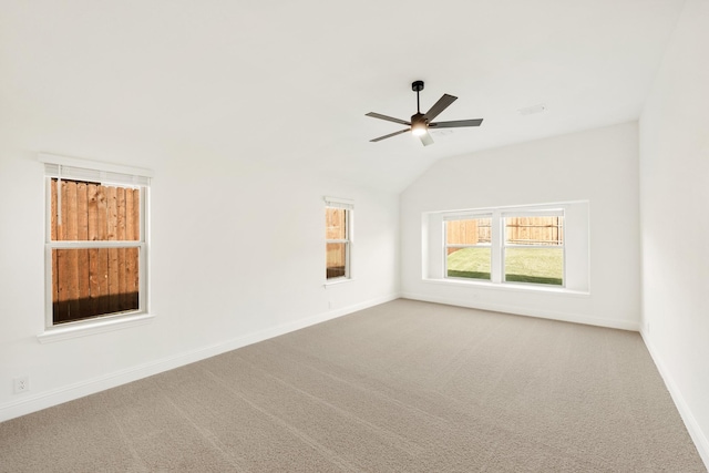 carpeted spare room featuring ceiling fan and vaulted ceiling