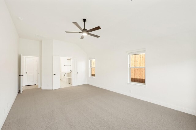 unfurnished bedroom featuring light carpet, connected bathroom, ceiling fan, and lofted ceiling