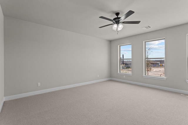 spare room featuring a ceiling fan, carpet flooring, visible vents, and baseboards