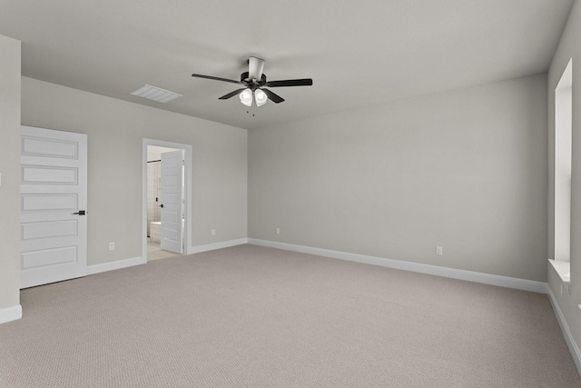 empty room with a ceiling fan, light colored carpet, visible vents, and baseboards