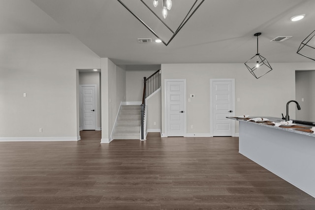 kitchen with dark wood-style floors, decorative light fixtures, visible vents, open floor plan, and a sink