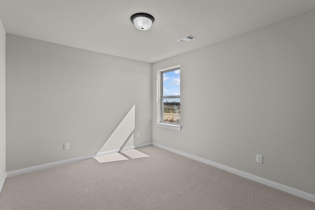 empty room with light colored carpet, visible vents, and baseboards