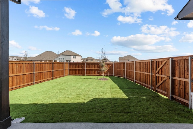 view of yard featuring a fenced backyard and a residential view