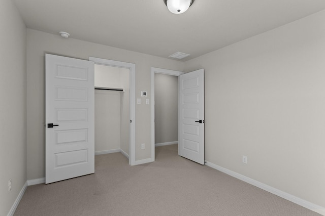 unfurnished bedroom with light carpet, a closet, and baseboards