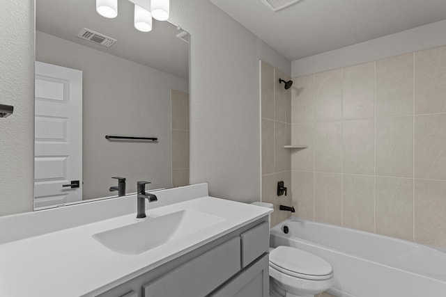 bathroom featuring visible vents, a textured wall, toilet, tub / shower combination, and vanity