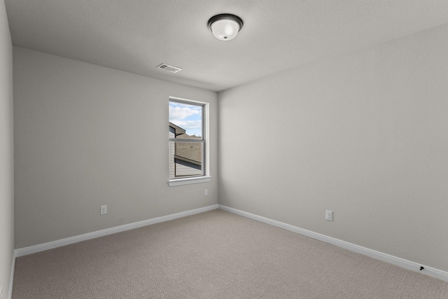 empty room featuring baseboards, visible vents, and carpet flooring