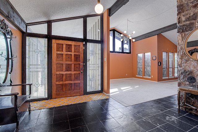 carpeted foyer entrance with vaulted ceiling, a chandelier, and a textured ceiling