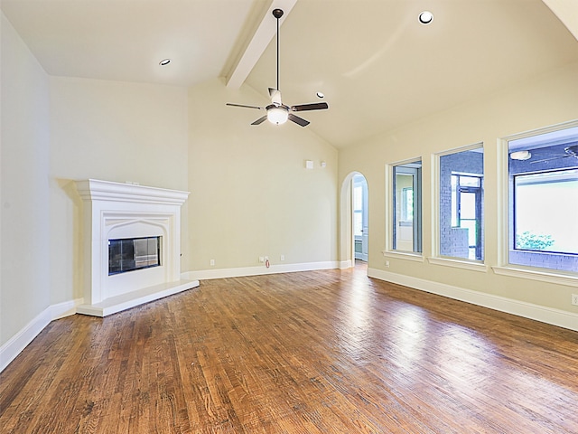 unfurnished living room with ceiling fan, lofted ceiling with beams, and dark wood-type flooring