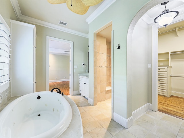 bathroom with ceiling fan, vanity, hardwood / wood-style flooring, tiled tub, and ornamental molding