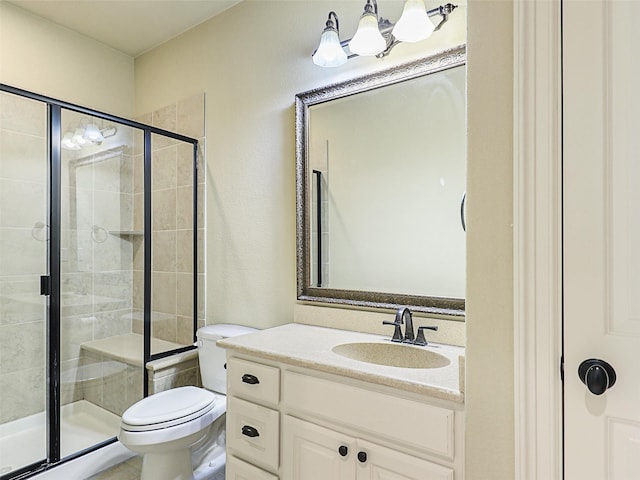 bathroom featuring a shower with door, vanity, and toilet