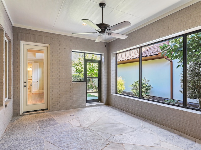 unfurnished sunroom featuring ceiling fan