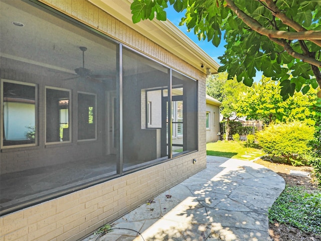 view of side of property featuring ceiling fan and a patio